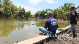 Sejumlah warga tampak setia menunggu kail pancingnya dilahap ikan. Lokasi mancing ini yakni di area persawahan yang masih terendam air di perkampungan Kalipuro, Dusun Kadunggabus, Desa Bandar Kedungmulyo, Jombang.