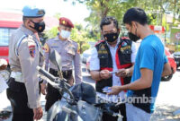 Kasat Resnarkoba Polres Jombang, Moch Mukid, bersama petugas, saat memeriksa identitas dan barang bawaan salah satu pelanggar prokes di simpang empat Stadion Merdeka .