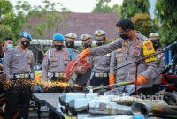 Wakapolres Jombang sedang memotong knalpot brong hasil razia 8 hari di bulan Ramadan, dengan mesin gerinda di halaman kantor Satlantas Polres Jombang.