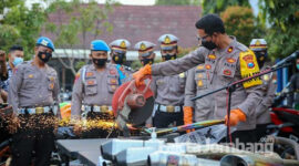 Wakapolres Jombang sedang memotong knalpot brong hasil razia 8 hari di bulan Ramadan, dengan mesin gerinda di halaman kantor Satlantas Polres Jombang.