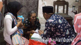 Kades Sidowarek Kecamatan Ngoro Jombang, Fatchur Rohman (Gus Fat) saat menyerahkan bantuan ke Haikal, bayi 3 bulan penderita hidrosefalus di Desa Bandung, Kecamatan Diwek, Jombang