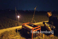 Seorang petani di Plandaan, Jombang, saat menyalakan dan menunggui genset untuk jebakan tikus beraliran listrik di sawahnya. 