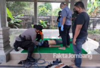 Petugas melakukan pemeriksaan pada tubuh korban gantung diri, pasca dievakuasi.