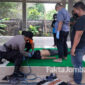 Petugas melakukan pemeriksaan pada tubuh korban gantung diri, pasca dievakuasi.