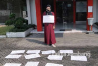 Fitria Cahyarani (40) warga Desa Bulurejo, Kecamatan Diwek, Kabupaten Jombang, menggelar demo tunggal di pelataran Kantor Cabang (Kancab) AJB Bumiputera Jombang, Senin (24/5/2021).
