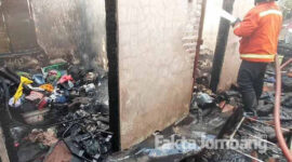 Petugas pemadam kebakaran saat melakukan pembasahan setelah berhasil memadamkan api yang membakar rumah di Dusun Ngrawan, Desa Pesantren, Kecamatan Tembelang, Kabupaten Jombang.