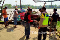 Warga dan petugas hendak mengevakuasi truk yang terperosok di bibir Sungai Brantas, Desa/Kecamatan Megaluh, Kabupaten Jombang.