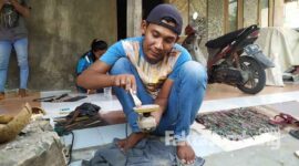 Baron saat menghaluskan ranting kayu pohon nangka yang dijadikannya sebagai pipa rokok atau once.