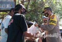 Kapolres Jombang AKBP Agung Setyo Nugroho, saat memberikan paket sembagi ke salah satu abang becak yang mangkal di kawasan Jombang Kota, Minggu Minggu (11/7/2021).