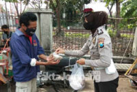 Kaur Mintu Satlantas Polres Jombang, Ipda Rita Puspita Sari saat membagikan nasi bungkus yang sebelumnya dibeli dari dagangan sejumlah PKL di Jombang.