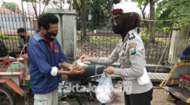 Kaur Mintu Satlantas Polres Jombang, Ipda Rita Puspita Sari saat membagikan nasi bungkus yang sebelumnya dibeli dari dagangan sejumlah PKL di Jombang.