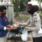 Kaur Mintu Satlantas Polres Jombang, Ipda Rita Puspita Sari saat membagikan nasi bungkus yang sebelumnya dibeli dari dagangan sejumlah PKL di Jombang.