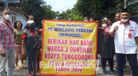 Aksi damai warga tiga dusun di Desa Tunggorono, Kecamatan/ Kabuapten Jombang, dengan membentang banner berisi tuntutan dana kompensasi 2019 ke PT Sengfong Moulding Perkasa.