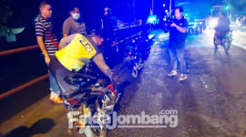 Petugas saat mengamankan kendaraan yang terlibat kecelakaan di jalan raya Jombang – Mojokerto, tepatnya di Desa Gambiran, Kecamatan Mojoagung, Kabupaten Jombang, Sabtu (26/2/2022) dini hari.