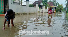 Sejumlah anak-anak warga Desa Trawasan, Kecamatan Sumobito, Kabupaten Jombang, menjadikan area banjir sebagai tempat bermain, Kamis (10/3/2022).