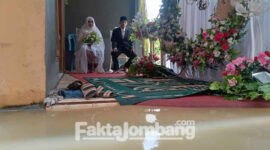 Acara resepsi pernikahan saat berlangsung saat banjir di Desa Trawasan, Kecamatan Sumobito, Kabupaten Jombang, Jumat (11/3/2022).