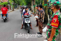 Anggota TNI membagikan takjil untuk pengguna jalan di depan Koramil 0814/01 Jombang dibantu anggota Pramuka, Jumat (22/4/2022) sore.