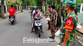 Anggota TNI membagikan takjil untuk pengguna jalan di depan Koramil 0814/01 Jombang dibantu anggota Pramuka, Jumat (22/4/2022) sore.