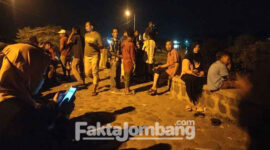 Warga sekitar sedang memadati area sungai Brantas, lokasi terceburnya satu keluarga asal Desa Banjardowo, Kecamatan/ Kabupaten Jombang, Sabtu (9/4/2022).