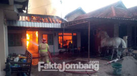 Petugas berupaya menjinakkan api yang membakar rumah sekaligus tempat usaha cor kuningan di Dusun Sanan selatan, Desa Mojotrisno, Kecamatan Mojoagung, Kabupaten Jombang