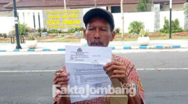 Ut, warga Desa Segodorejo, Kecamatan Sumobito, Kabupaten Jombang, saat menunjukkan surat panggilan dari Polres Jombang, usai dirinya dimintai keterangan oleh polisi.