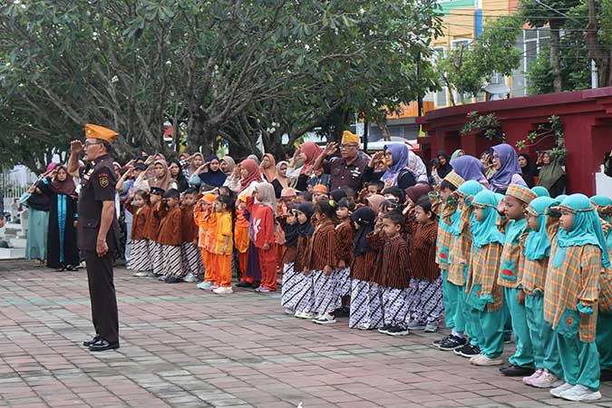 Ratusan anak TK di Jombang, sedang mengikuti upacara di pelataran TMP Jombang.