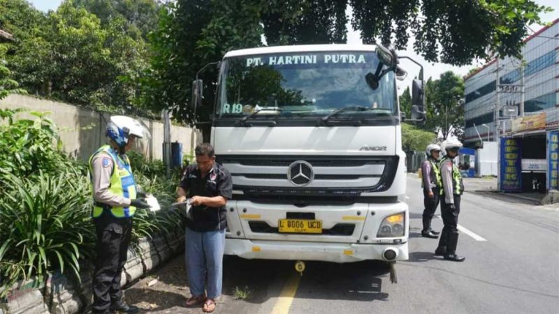 Petugas sedang memeriksa kelengkapan sopir truk yang parkir sembarangan di Jalan Gatot Subroto, Jombang.