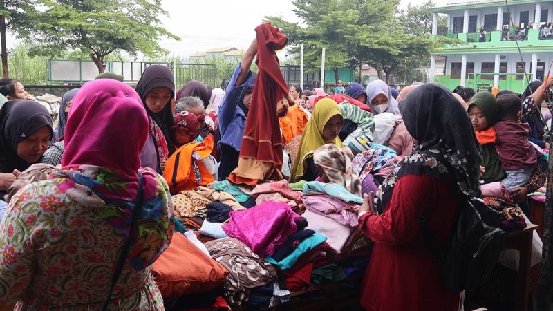 Suasana ibu-ibu sedang memilih pakaian di Bazar Baju Gratis yang digelar Yayasan Darul Ulum Desa Bandung, Jombang.